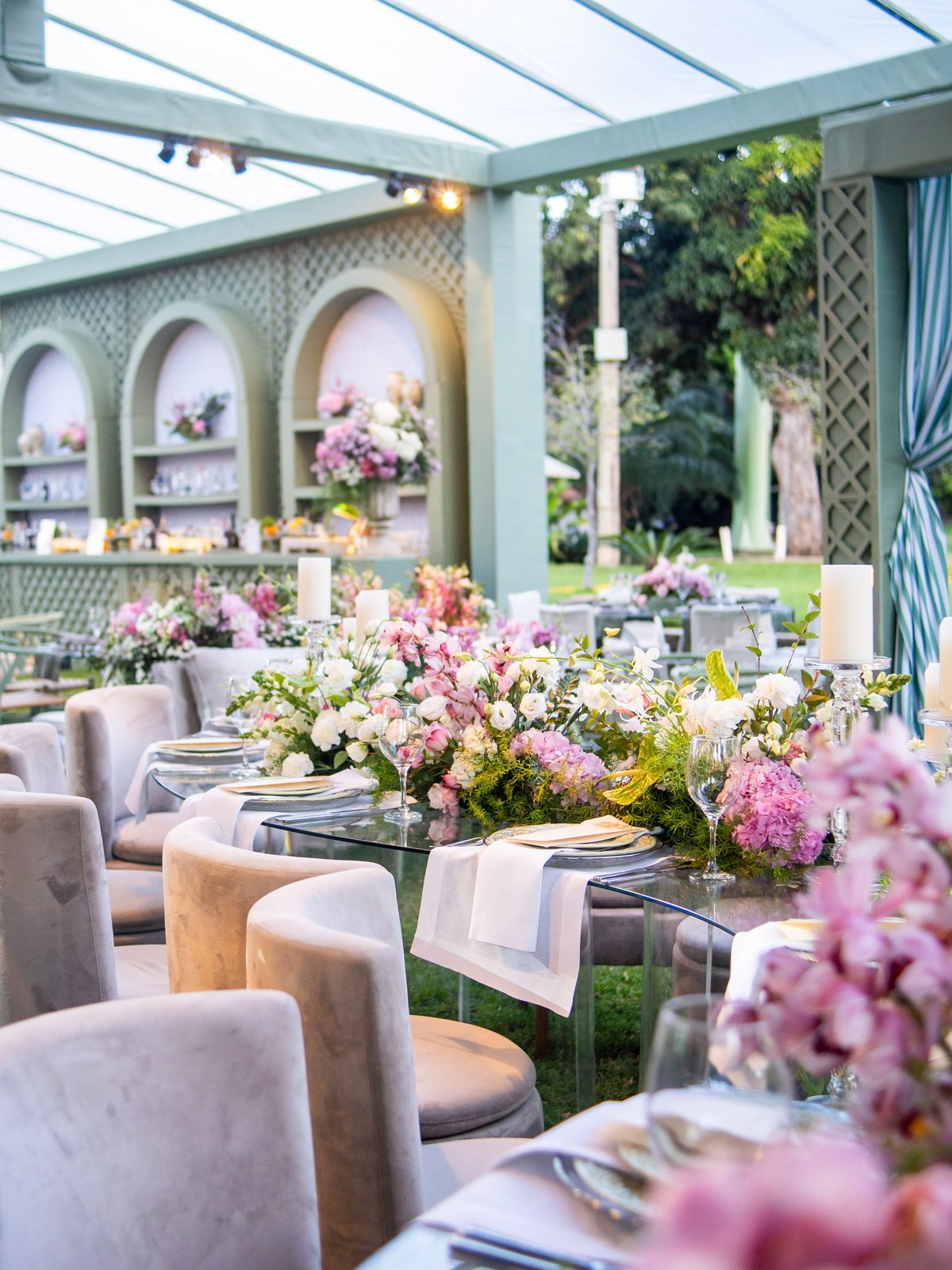 Garden marquee set for dinner, tables under a glass canopy
